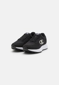 Pantofi sport negri cu un superior din plasă și accente din piele întoarsă, talpă intermediară albă și un logo proeminent pe lateral. Sistem de închidere cu șiret și talpă texturată.