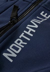 Ciemnoniebieska tkanina o gładkiej fakturze, z wyraźnym białym napisem "NORTHVILLE" oraz czarnym detalem zamka.