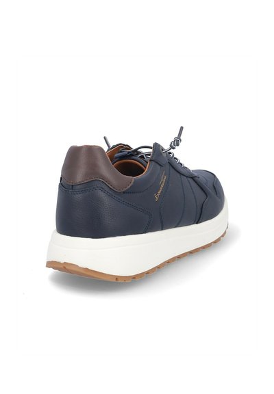 Zapatilla deportiva de cuero azul oscuro con un acento de cuero marrón en el talón, media suela blanca y suela exterior de goma texturizada. Cuenta con cordones grises y detalles de costura.