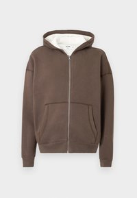 Hnedá mikina na zips so sivým vnútrom, veľkými prednými vreckami a rebrovanými manžetami. Vyrobená z mäkkej tkaniny s uvoľneným strihom a jednoduchým prešitím.