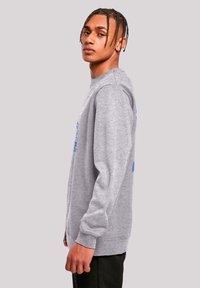 Grey sweatshirt with long sleeves, crew neck, and blue graphic print on front. Made of fleece material, featuring ribbed cuffs and hem.