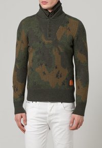 Gestrickter Pullover in grünem und braunem Tarnmuster, mit hohem Kragen und drei Knöpfen, sowie gerippten Bündchen und Saumdetails.