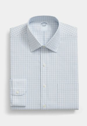 Bílá košile s modrým mřížkovým vzorem, s knoflíkovou légou, ohrnutými rukávy a špičatým límcem, úhledně složená na jednoduchém pozadí.