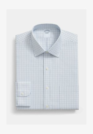 Bílá košile s modrým mřížkovým vzorem, s knoflíkovou légou, ohrnutými rukávy a špičatým límcem, úhledně složená na jednoduchém pozadí.