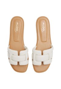 Des sandales blanches à glissière avec une finition lisse et mate et une large sangle présentant des découpes. Semelle intérieure beige avec un branding subtil. Design à embout carré.