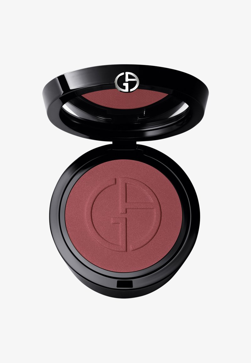 Rund kompakt blush med svart emballasje, som har en matt burgunderfarge innvendig, preget med et logo-mønster. Åpnes med hengsel.