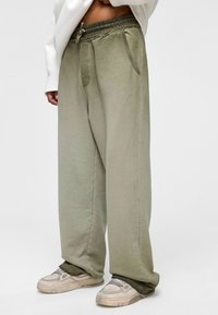 Lichtgroene, ruimvallende sweatpants van een zacht materiaal, met een elastische tailleband, twee zijzakken en een omslag aan de onderkant.
