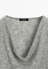 Lichtgrijze zachte gebreide trui met een brede kraag en een zwart label binnenin de kraag met de tekst "Massimo Dutti, Made in China".