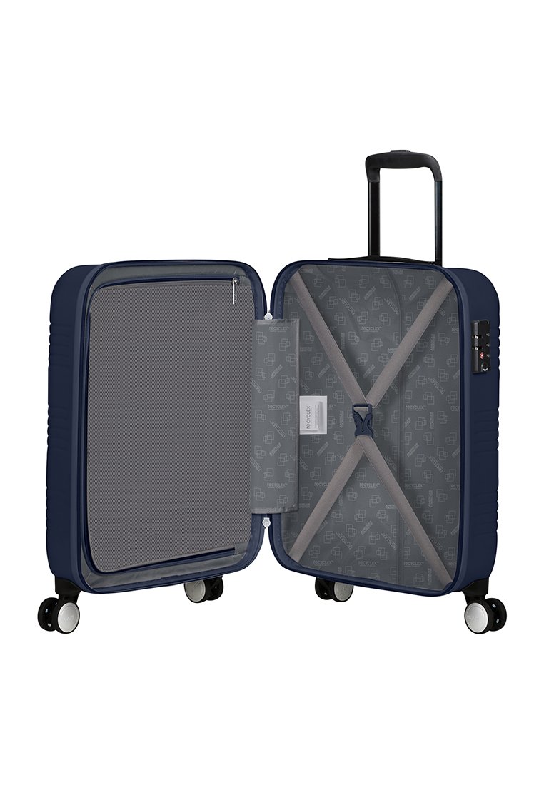 Valigia rigida blu navy con fodera interna grigia, tasche con zip, cinghie di compressione e ruote scorrevoli. Forma rettangolare compatta.