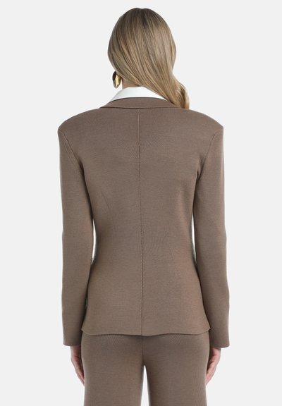 Bruine gebreide blazer met een gestructureerde silhouette, voorzien van een witte contrasterende kraag en subtiele verticale naden. Glad materiaal, op maat gesneden pasvorm.