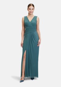 Teal maxi šaty s hlubokým V výstřihem, nařaseným tělem, splývavou sukní a vysokým rozparkem. Hladká látka a elegantní silueta.
