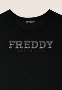 T-shirt nera a maniche corte con colletto tondo, caratterizzata dalla parola "FREDDY" in grandi lettere luccicanti e "TIME TO SHINE" sotto in testo più piccolo.