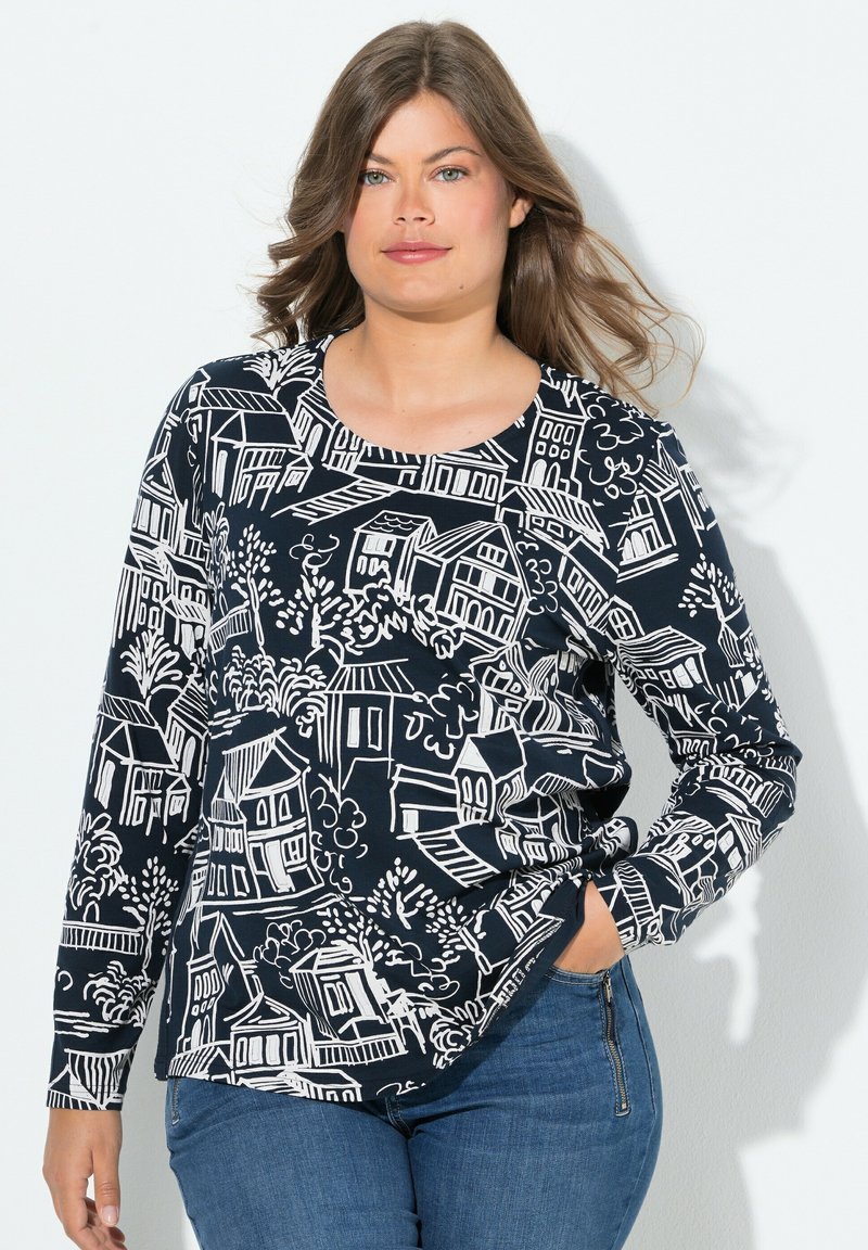 Langärmliges Oberteil aus navyfarbigem Stoff mit einem Muster von weißen Häusern und Bäumen. Runde Ausschnitt, lockerer Schnitt, leichtes Material und gerader Saum.