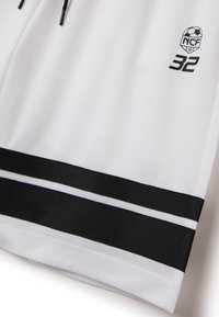 Pantalones cortos deportivos blancos hechos de un tejido transpirable. Presentan rayas negras en el dobladillo y un logo con el número 32 impreso en negro.