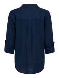 Temno modra majica z dolgimi rokavi, z zvitimi manšetami in šivom na zadnjem delu, prikazana od zadaj.