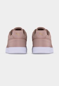 Ζευγάρι ανοιχτό ροζ αθλητικά παπούτσια Puma με λευκές σόλες, απεικονιζόμενα από πίσω σε λευκό, απλό φόντο.