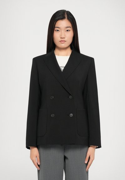 Black double-breasted blazer with notched lapels, featuring two front pockets and button closures. Smooth fabric and tailored fit.