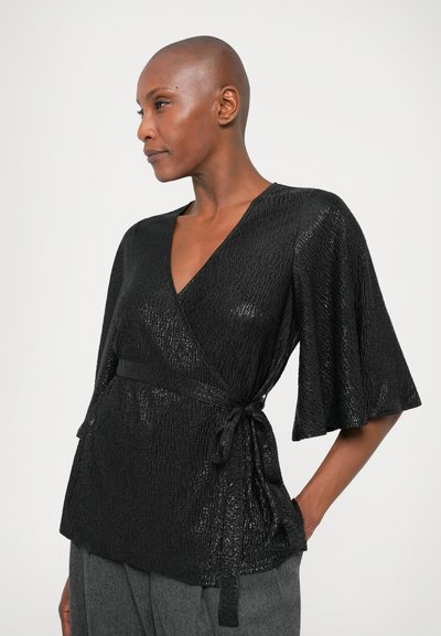 Blouse noire à nouer, en tissu texturé, avec des manches courtes évasées et un lien à la taille, au fini subtil et à la conception structurée.