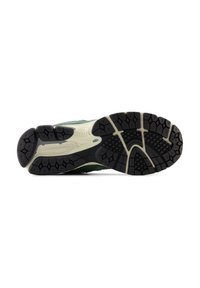 Running shoe sole featuring a black rubber tread with a textured pattern for grip, and an off-white midsole for cushioning.