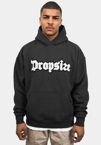 Sort hættetrøje med frontlomme, fremhævet af et broderet hvidt "Dropsize" logo. Blødt stof, ribbede manchetter og kant.