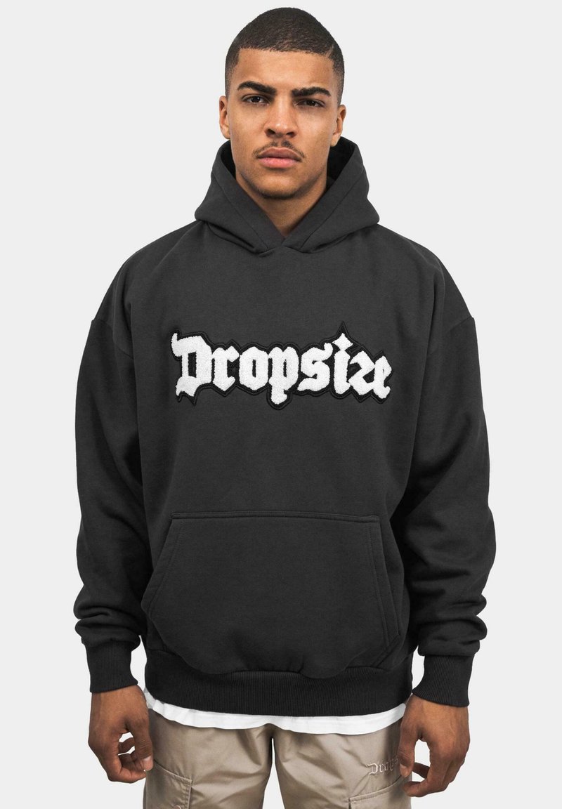 Sort hættetrøje med frontlomme, fremhævet af et broderet hvidt "Dropsize" logo. Blødt stof, ribbede manchetter og kant.