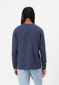 Long-sleeve navy blue t-shirt, cotton material, round neckline, straight cut, minimal design, smooth texture, and no visible patterns or accents.