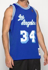Canotta da basket blu in rete con "Los Angeles" in bianco, numero "34" in azzurro chiaro, e un'etichetta logo all'orlo.