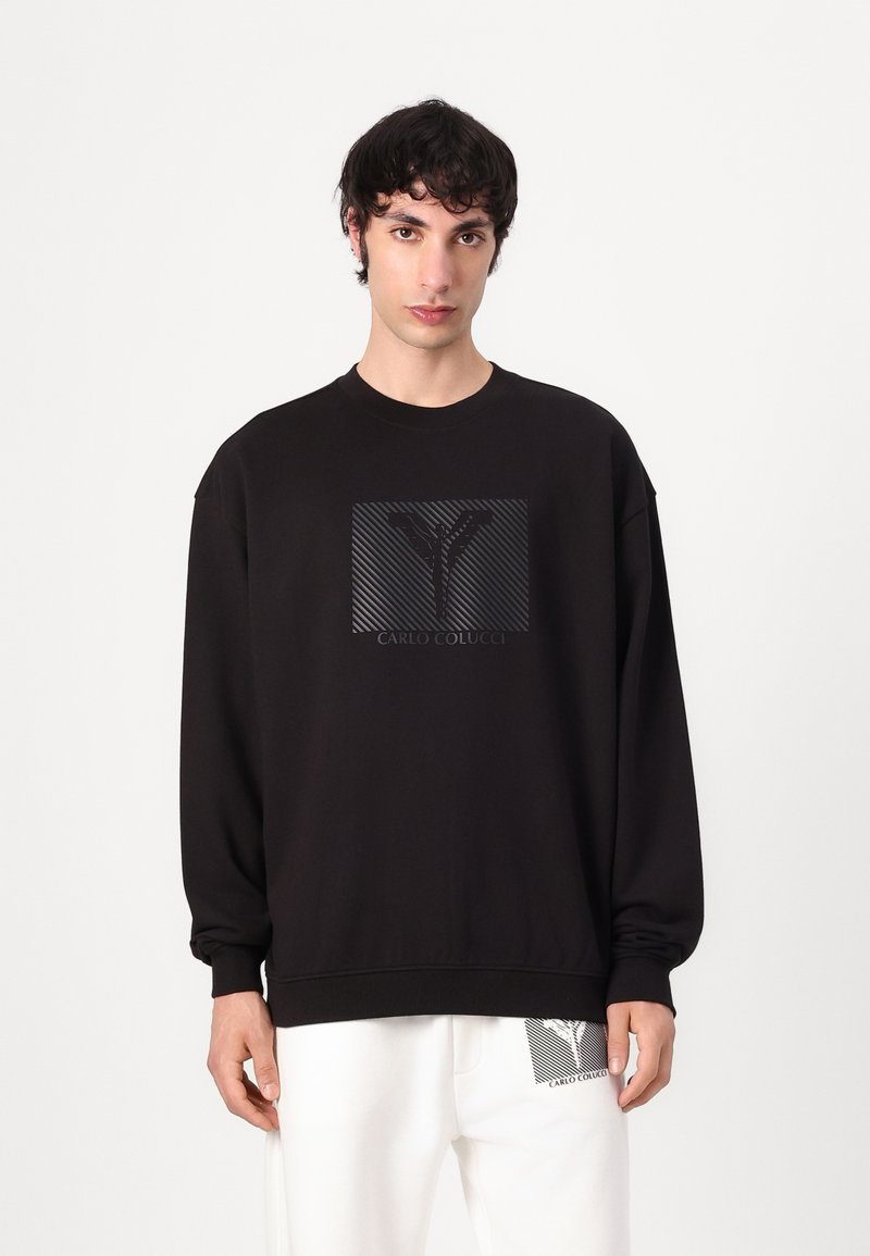 Zwarte sweatshirt met een gestructureerd grafisch logo op de voorkant. Heeft lange mouwen, een ronde halslijn en geribbelde boorden.