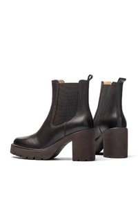 Stivaletti in pelle marrone con un tacco spesso, pannelli laterali elasticizzati e una finitura liscia, dotati di un occhiello sul retro per facilitarne l'indossamento.
