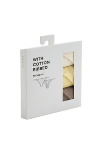 Paquet de trois strings en coton côtelé beige, jaune et marron, avec texte produit et illustrations des strings sur une boîte en carton blanche.