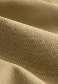 Svetlohnedá látka s hladkou textúrou, zobrazuaujúca jemný diagonálny vzor a mierny lesk. Sophisticated a rovnomerné rozloženie farieb.