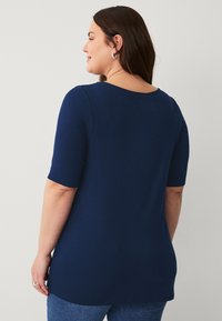 Navyblaues kurzärmliges Oberteil aus glattem Stoff, mit weitem Ausschnitt und lässiger Passform, seitlichen Schlitzen am Saum.