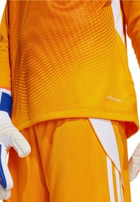 Oranje jersey met een gradient patroon, gecombineerd met oranje shorts. Voorzien van witte accenten. Gemaakt van ademend Aeroready-materiaal.