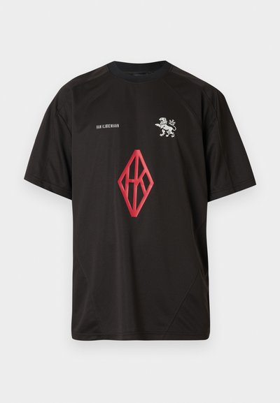 Black short-sleeve t-shirt made of lightweight fabric, featuring a lion emblem and a red diamond logo on the front.