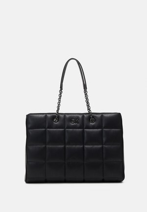 Black quilted handbag made of leather with a rectangular shape, featuring chain handles and embossed logo on the front.