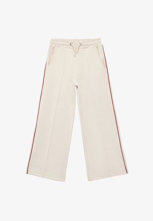 Pantalones de chándal beige de pierna ancha con cinturilla elástica, cordón, bolsillos laterales y una franja burdeos a lo largo de los lados exteriores. Textura de tela suave.