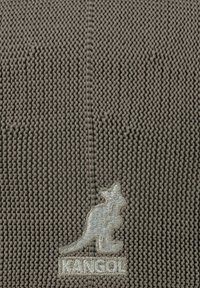 Gorra Kangol en suave tejido de punto gris. Presenta un patrón texturizado y un logotipo de canguro bordado en gris claro en la parte frontal.