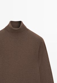 Maglione a collo alto marrone realizzato in tessuto a costine, con un design aderente e un collo alto. Texture liscia con maniche lunghe.
