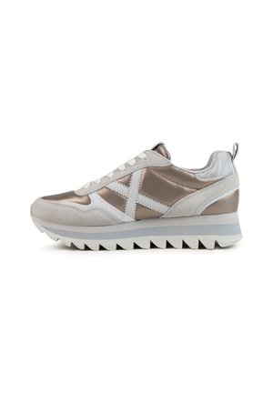 Sneaker con una toma in suede grigio chiaro, dettagli metallici argento, lacci bianchi e una suola in gomma bianca testurizzata con bordi seghettati.