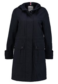 Cappotto impermeabile blu navy con cappuccio, dotato di chiusura frontale con zip, due ampie tasche anteriori e dettagli con bottoni. Tessuto liscio e design di media lunghezza.