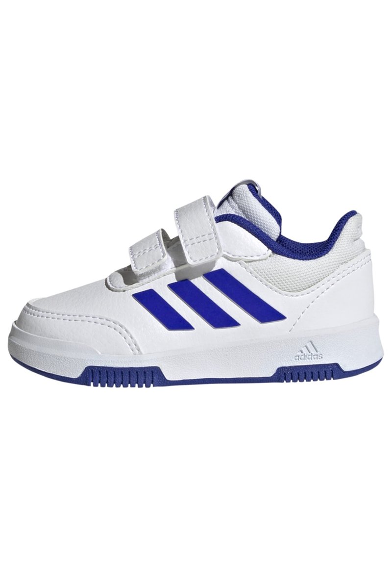 Zapatilla deportiva blanca con acentos azules, que cuenta con dos correas de Velcro, parte superior sintética, suela de goma y tres franjas azules distintas en el lateral.