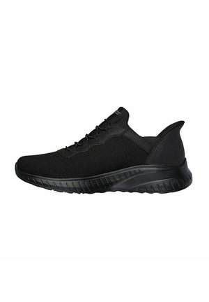 Black athletic shoes with a mesh upper, rounded toe, and textured rubber sole. Features subtle stitching and a pull tab at the heel.