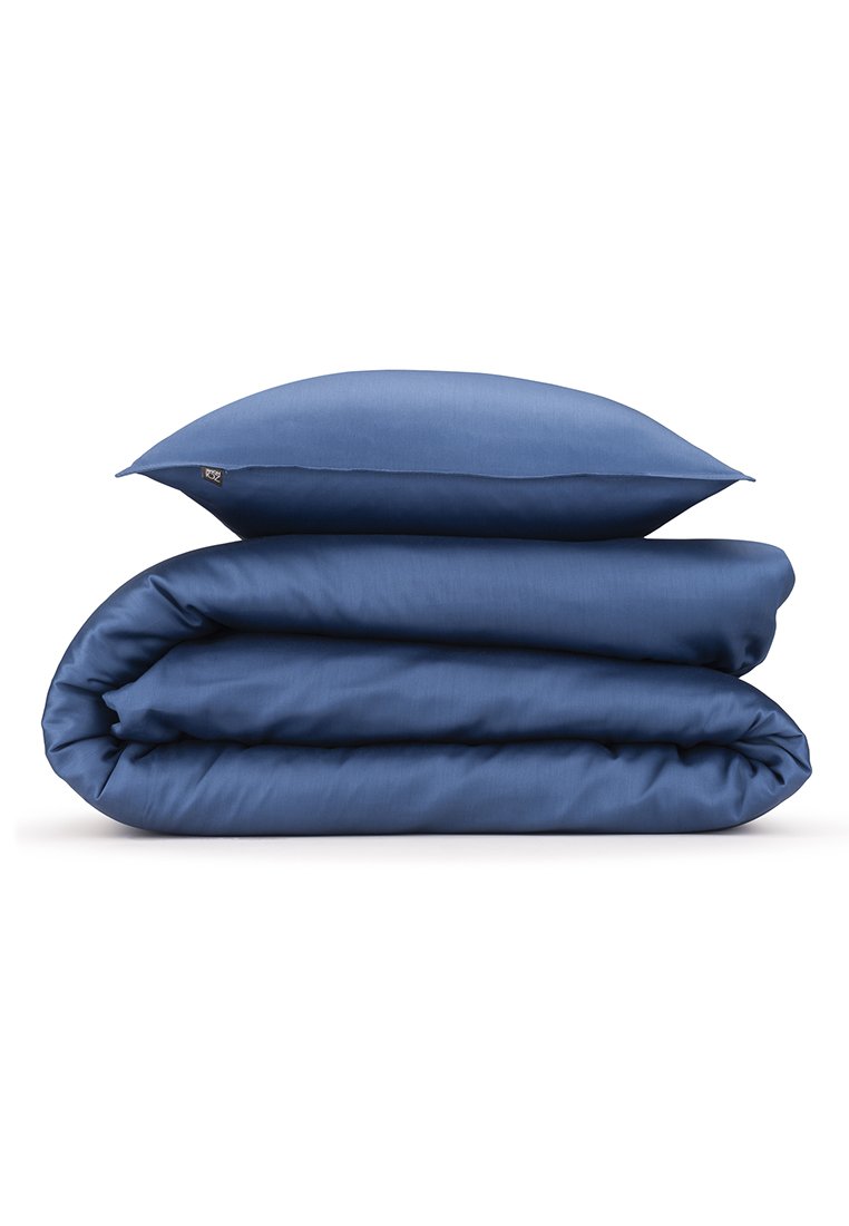Modrá ložní souprava skládající se z peřiny a polštáře. Jemná látka s hladkým povrchem, pečlivě složená bez viditelných vzorů nebo kovových komponentů.