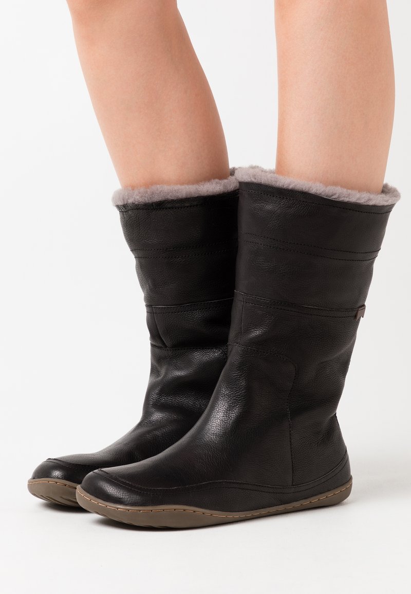 Schwarze Lederstiefel bis zum Knie mit einem grauen Fleecefutter, glatter Textur, abgerundetem Zehenbereich und genähten Gummisohlen-Details.