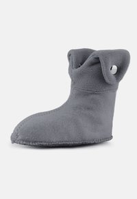 Chausson d'intérieur en tissu gris doux avec revers rabattable et œillets métalliques circulaires de chaque côté pour un enfilage facile.