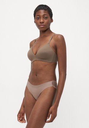 Beha- en slipset in beige. Beha heeft verstelbare banden en een diepe halslijn. De slip heeft een kantafwerking aan de zijkant. Gladde textuur.
