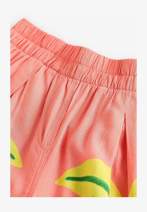 Coral-colored fabric shorts with an elastic waistband, featuring yellow leaf patterns and visible stitching details. Soft texture, relaxed fit.