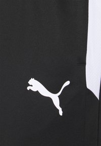 Shorts deportivos negros de tejido suave con acentos blancos. Destacable logo blanco de Puma en el muslo izquierdo y detalles de malla en los lados.