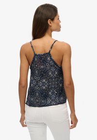 Granatowa, bezrękawnikowa bluzka z misternym wzorem paisley, wykonana z lekkiego materiału, z regulowanymi ramiączkami oraz luźnym krojem, idealna na co dzień.