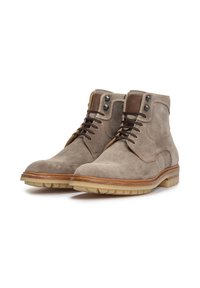 Botas de tobillo de ante gris con punteras redondeadas, detalles en cuero marrón, suelas de color neutro y cordones oscuros en contraste. Herrajes hexagonales en la parte superior.